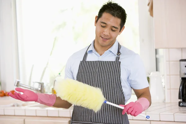 Man håller duster och bär gummihandskar — Stockfoto