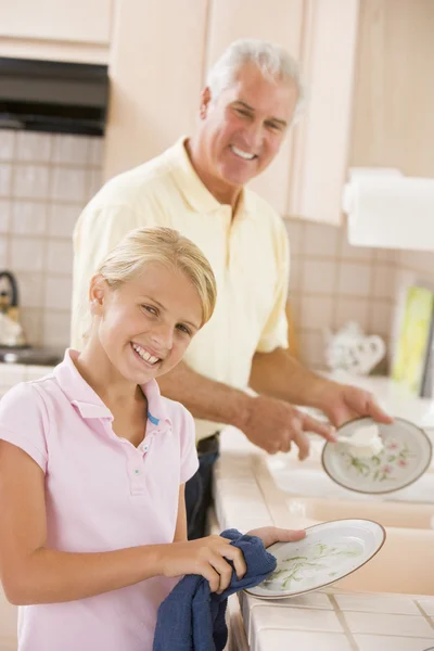Дідусь і онука миють посуд разом — стокове фото