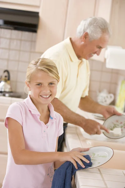 Großvater und Enkelin reinigen gemeinsam Geschirr — Stockfoto