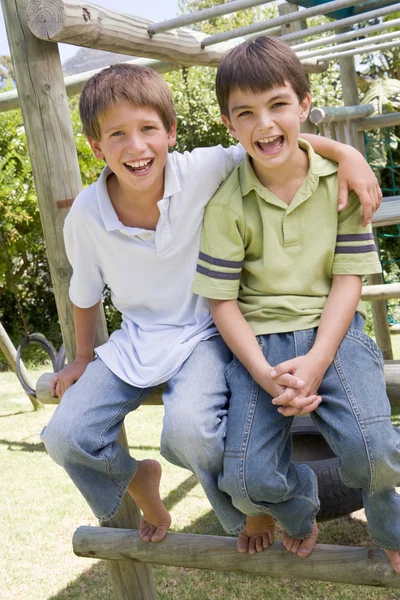 Due giovani amici maschi in un parco giochi sorridenti — Foto Stock
