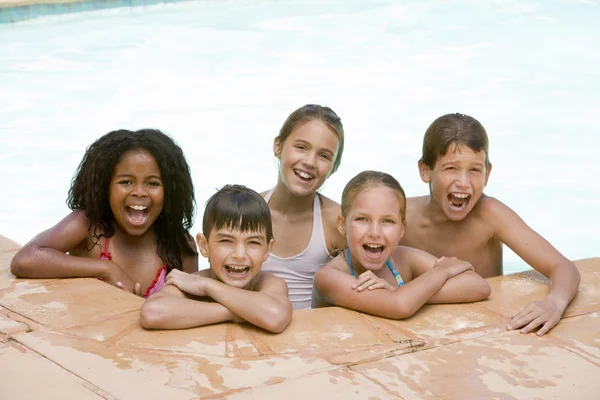 Five young friends in swimming pool smiling — Stock Photo, Image