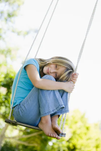 Swing gülümseyerek oturan genç kız — Stok fotoğraf