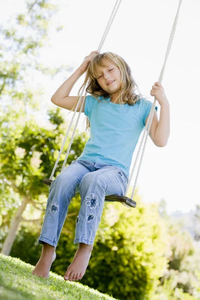 Ung flicka sitter på swing leende — Stockfoto