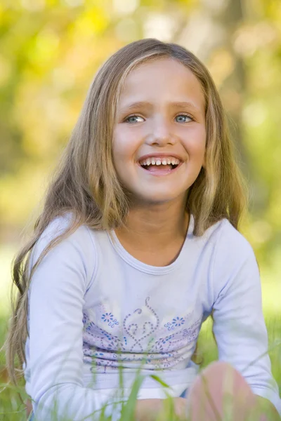Junges Mädchen Sitzt Freien Und Lächelt — Stockfoto