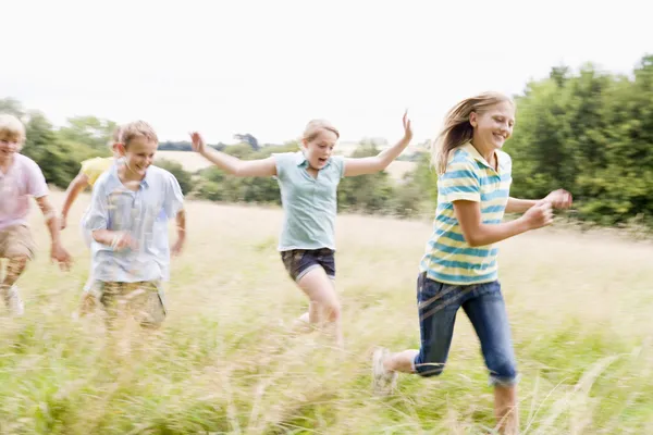 Fünf Junge Freunde Laufen Lächelnd Auf Einem Feld Herum — Stockfoto