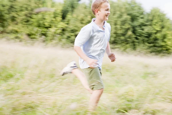 Νεαρό Αγόρι Που Τρέχει Ένα Πεδίο Που Χαμογελά — Φωτογραφία Αρχείου