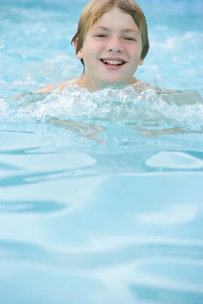 Young boy in swimming pool smiling — Zdjęcie stockowe