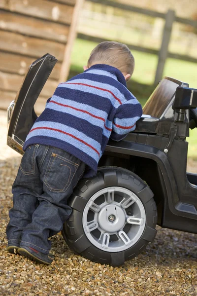 Młody chłopak gra na zewnątrz z zabawka ciężarówka — Zdjęcie stockowe