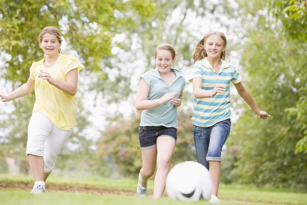 Three young girl friends playing soccer — Stock Photo, Image