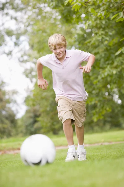 Молодий хлопчик грає у футбол — стокове фото