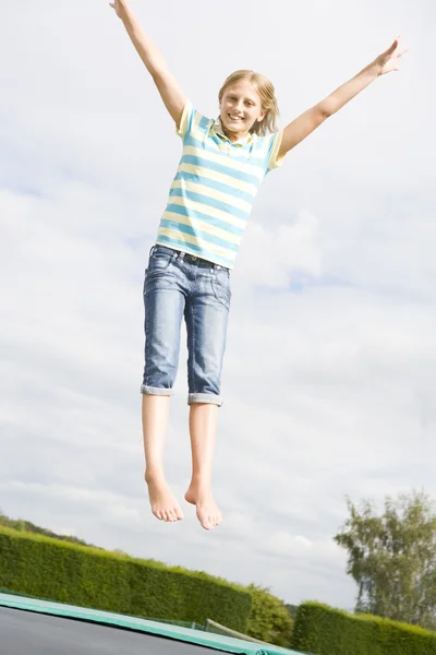 Genç Kız Gülümseyerek Trambolin Üzerinde Atlama — Stok fotoğraf