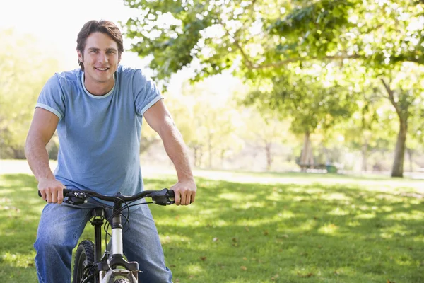 Man outdoors on bike smiling Stock Image