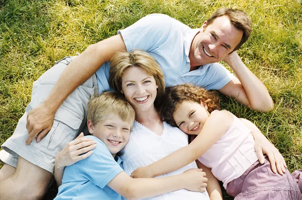 Family Lying Outdoors Smiling Stock Image
