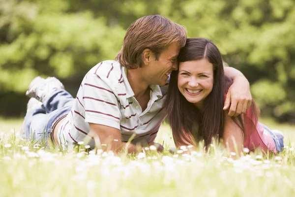 Couple lying outdoors smiling Royalty Free Stock Photos