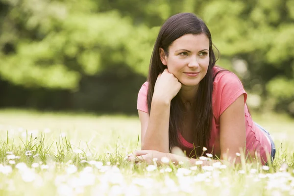 Woman lying outdoors smiling Stock Picture