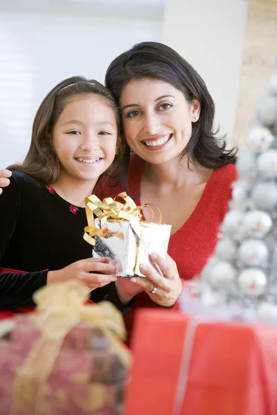 Chica sorprendiendo a su madre con regalo de Navidad Imagen de archivo