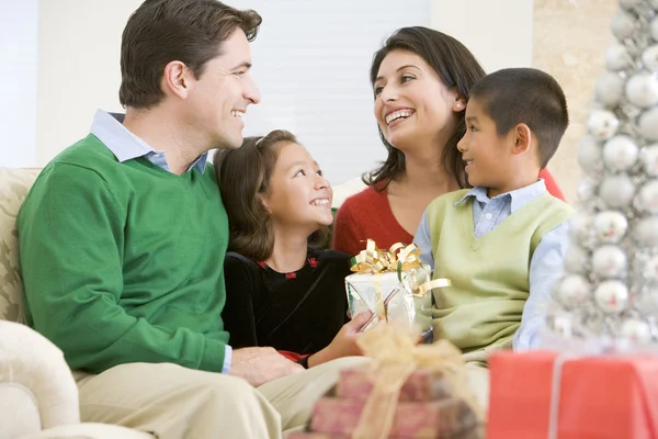 Familia Sonriendo Uno Otro Sosteniendo Regalo Navidad Imagen de archivo