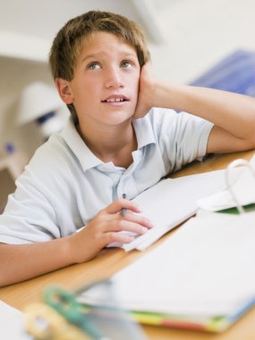 Young Boy Doing Homework In His Room clipart