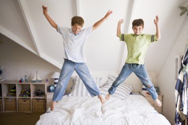 Young Girl Jumping On Her Bed clipart