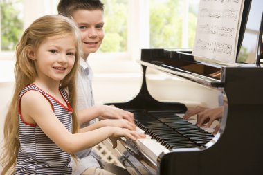 Brother And Sister Playing Piano clipart