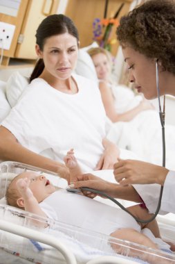 Doctor checking baby's heartbeat with new mother watching clipart