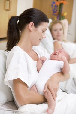 New mother with crying baby in hospital clipart