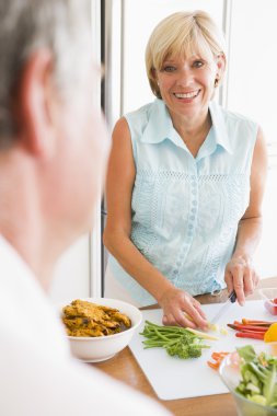 Woman Talking To Husband As She Prepares A meal,mealtime clipart