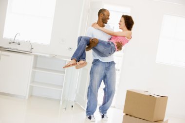 Husband holding wife in new home smiling clipart