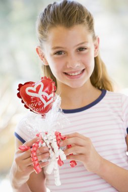 Young girl on Valentine's Day holding love themed balloon smilin clipart