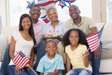 Family in living room on fourth of July with flags and cookies s clipart