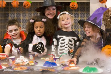 Four young friends and a woman at Halloween eating treats and sm clipart