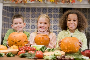 Three young friends on Halloween with jack o lanterns and food s clipart