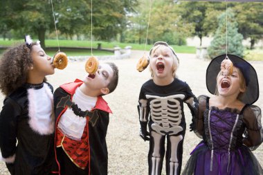 Four young friends on Halloween in costumes eating donuts hangin clipart