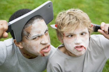 Two young boys with scary Halloween make up and plastic knives t clipart