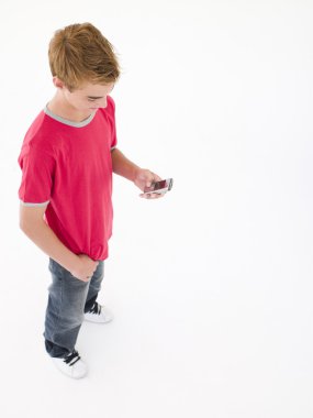 Young boy using cellular phone clipart