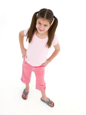 Young girl standing with hands on hips smiling clipart