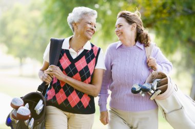 Female Friends Enjoying A Game Of Golf clipart