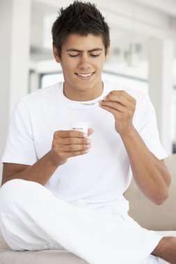 Young Man Eating Yogurt clipart