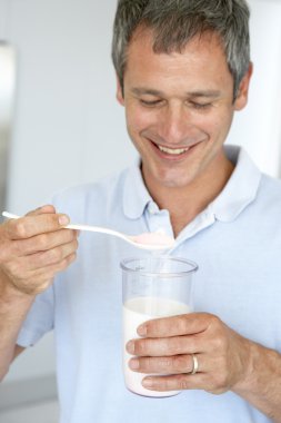 Middle Aged Man Preparing A Dietary Supplement clipart