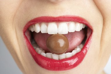 Close-Up Of Woman's Mouth Biting On Chocolate clipart