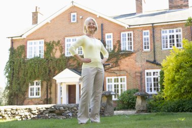 Senior Woman Standing Outside House clipart