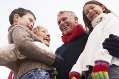 Grandparents Hugging Their Grandchildren clipart