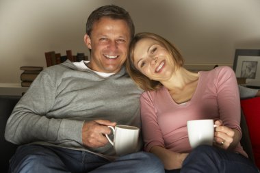 Couple With Coffee Mugs Watching Television clipart