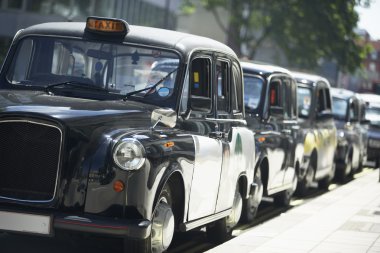 London Taxis Lined Up On Sidewalk clipart