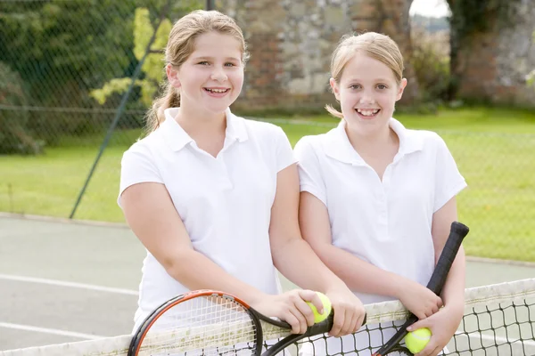 Két Fiatal Lány Barátai Tenisz Bíróság Mosolyogva Ütők — Stock Fotó