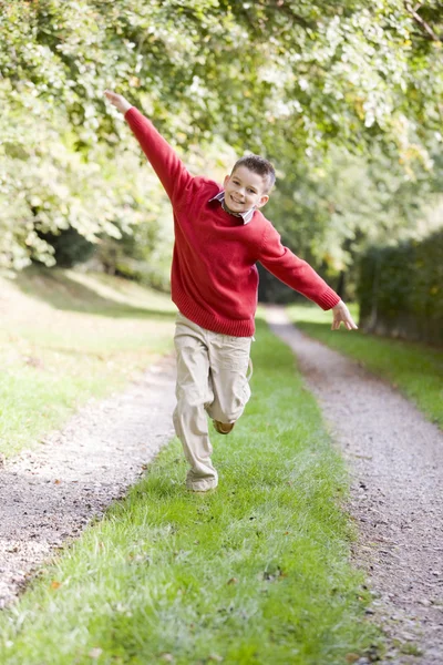 Νεαρό Αγόρι Που Τρέχει Μια Πορεία Που Είναι Χαμογελώντας Εξωτερικούς — Φωτογραφία Αρχείου