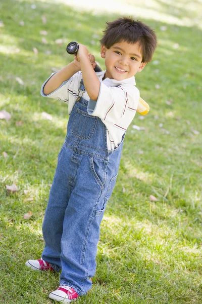 Joven niño sosteniendo bate de béisbol al aire libre sonriendo —  Fotos de Stock