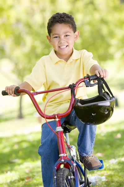 Мальчик на велосипеде на улице улыбается — стоковое фото