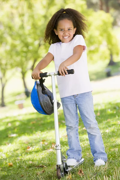 Молодая девушка на улице на скутере улыбается — стоковое фото