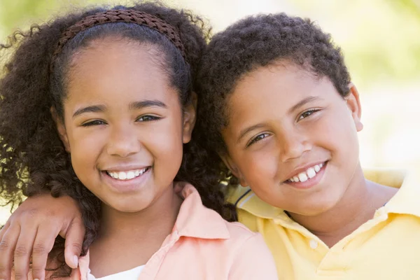 Brother and sister outdoors smiling — Stock Photo, Image